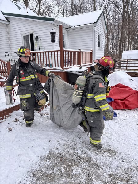 Crews hand carrying insulation out of the attic at today's fire.